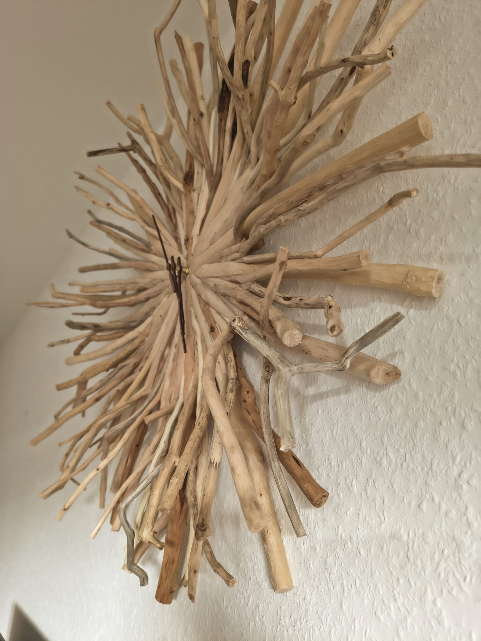 Détail des aiguilles de l'horloge posées sur le cœur de bois flotté
